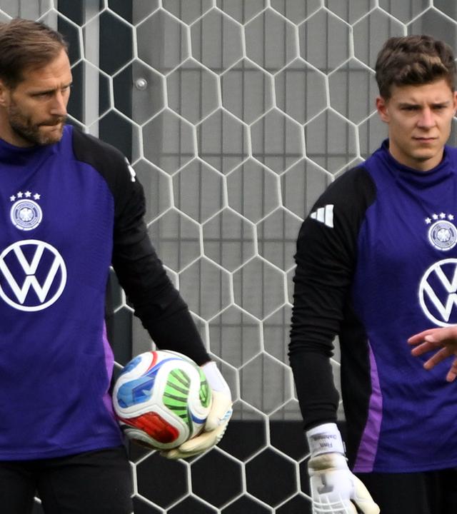 Torwarttrainer Andreas Kronenberg (l) spricht während des Trainings mit Torwart Oliver Baumann und Torwart Finn Dahmen