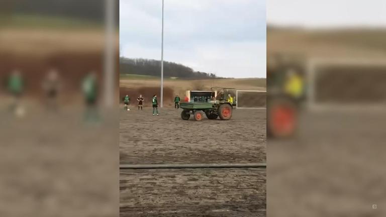 Traktor fährt während Fußballspiel über Platz