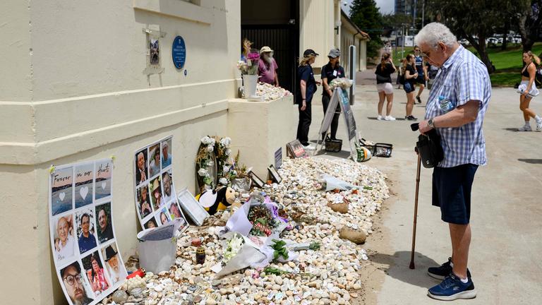 Ein Mann liest Gedenktexte für die Opfer des Bondi-Beach-Anschlags beim Nationalen Trauertag in Sydney, 22. Januar 2026.