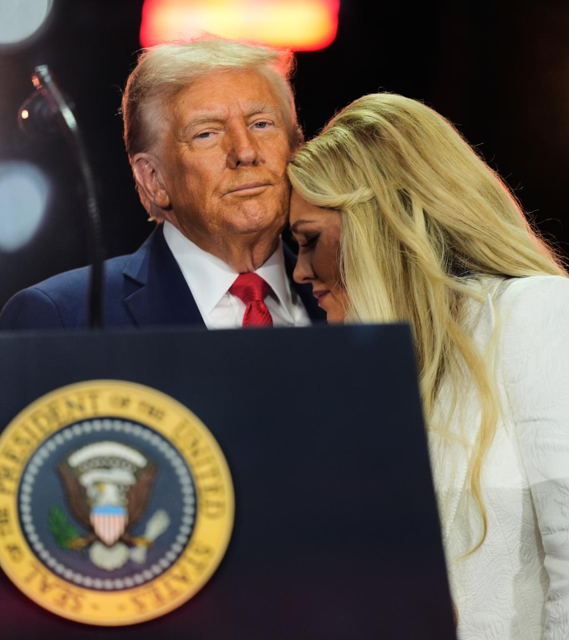 Donald Trump und Erika Kirk bei der Gedenkfeier für Charlie Kirk. Trump hält Erika Kirk in den Armen