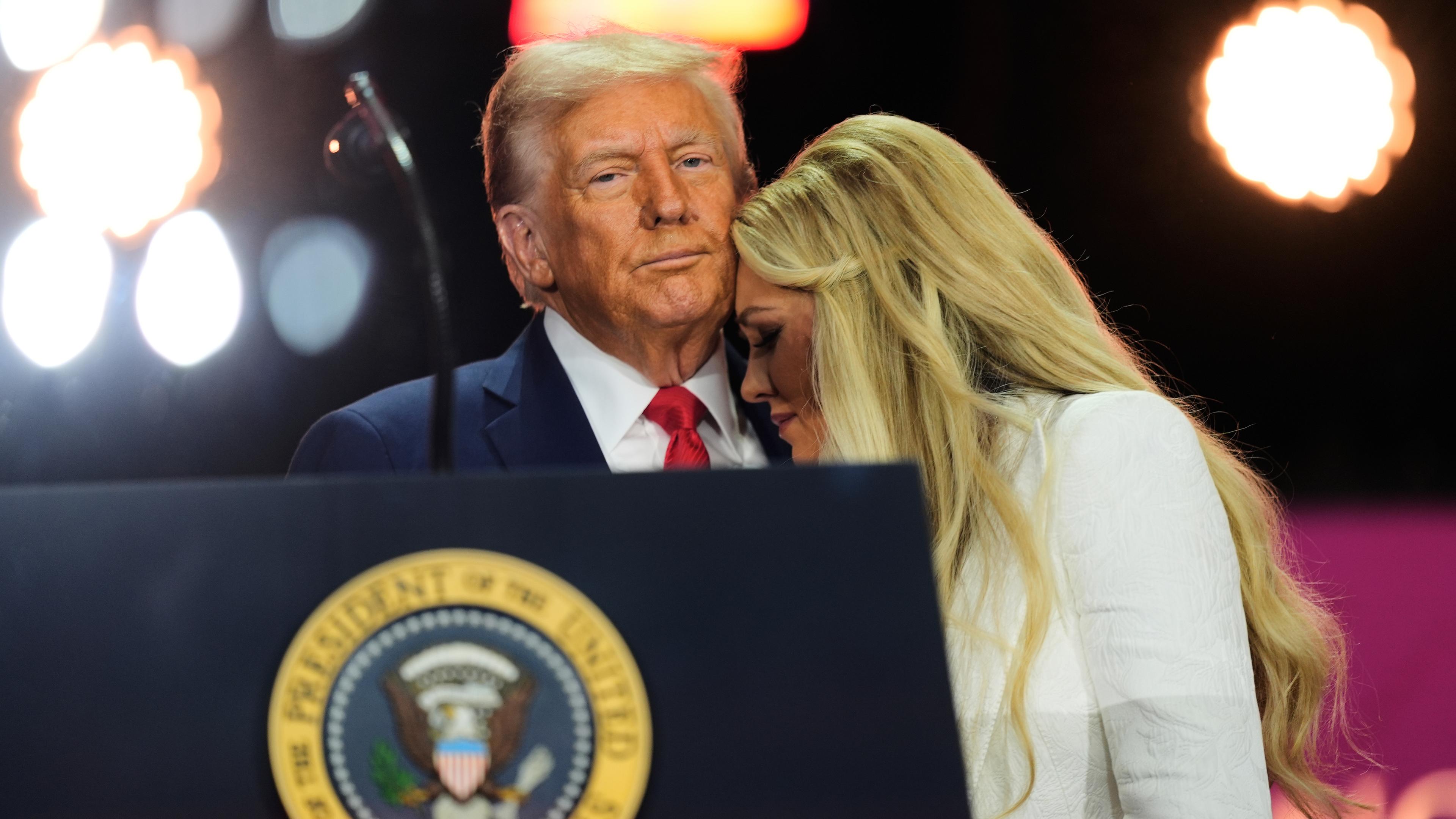 Donald Trump und Erika Kirk bei der Gedenkfeier für Charlie Kirk. Trump hält Erika Kirk in den Armen