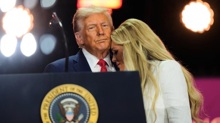 Donald Trump und Erika Kirk bei der Gedenkfeier für Charlie Kirk. Trump hält Erika Kirk in den Armen