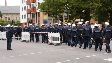 30.08.2025, Saarland, Saarlouis: Polizisten gehen vor dem Trauergottesdienst für den in Völklingen erschossenen Polizisten,  Polizeioberkommissar Simon B., auf der Straße.