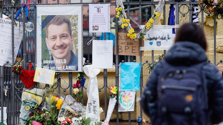 Eine Frau steht am Maktplatz an der Trauerstelle für den getöteten Polizisten.