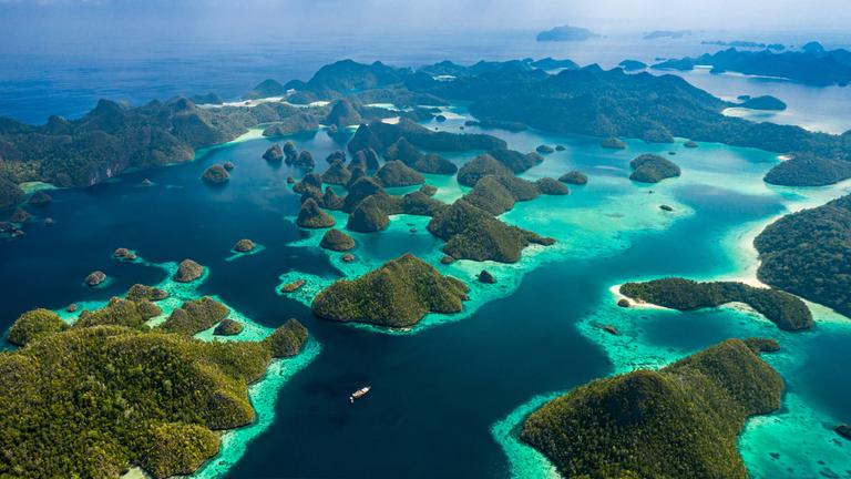 Blick von oben auf ein Labyrinth aus kleinen grünen Inseln im Meer.