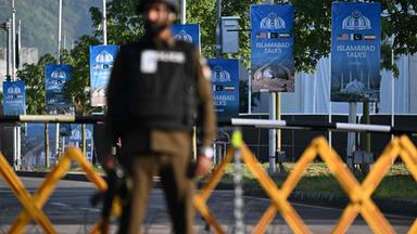 Ein Polizist steht in der Nähe des Serena Hotels im sogenannten "Red Zone" -Viertel in Islamabad Wache neben Plakaten.