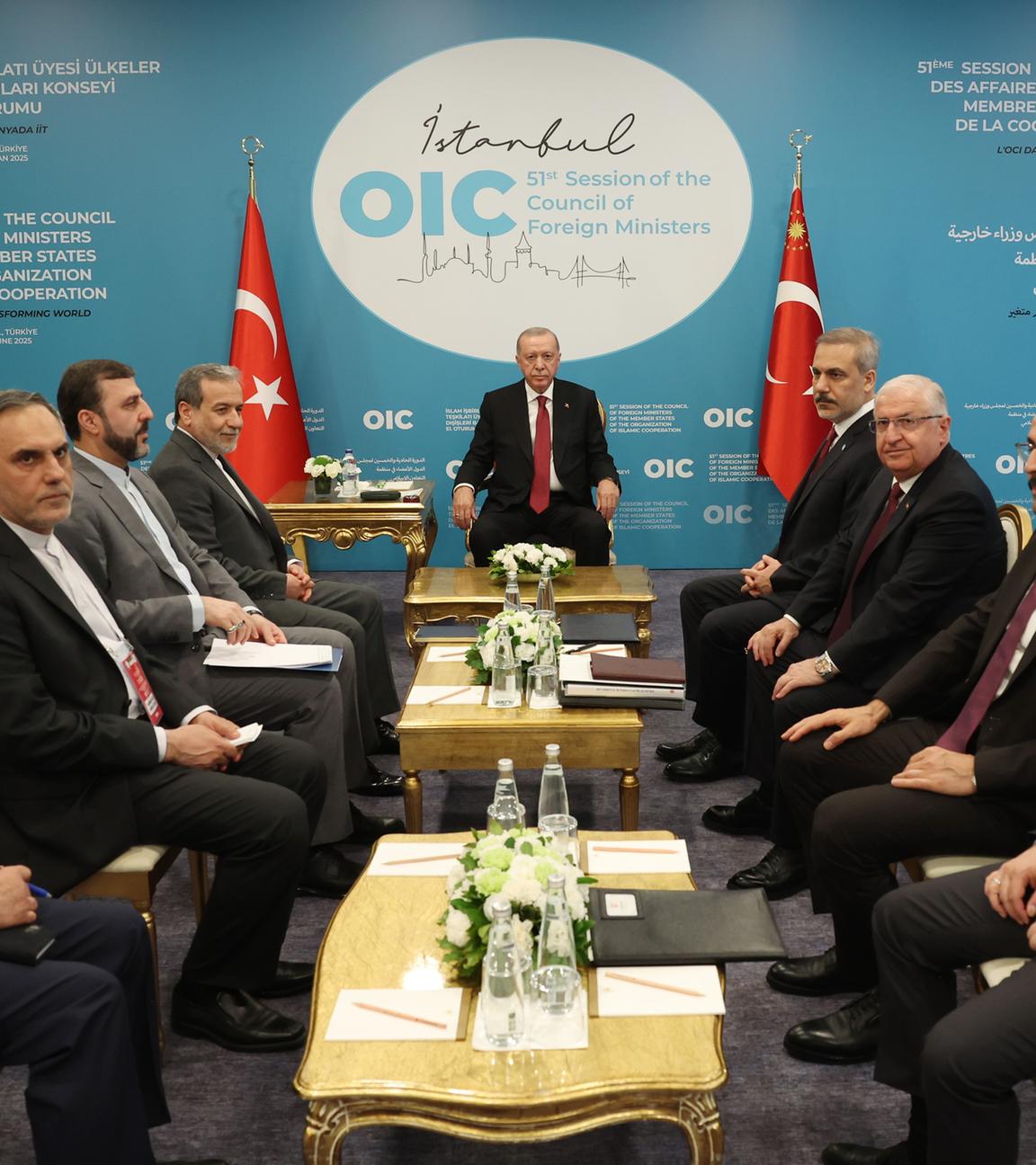 Ein Konfernzraum. Der türkische Präsident sitzt vor Kopf. Die anderen Staatsoberhäupter sitzen an der Seite in Anzügen. In der Mitte stehen mehrere kleine Tische.
