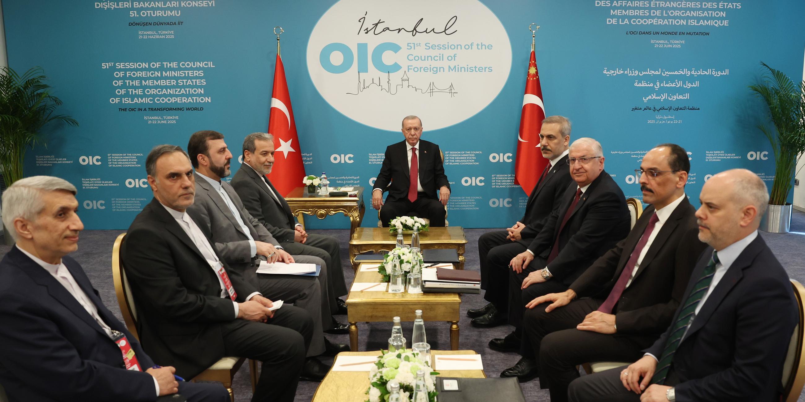 Ein Konfernzraum. Der türkische Präsident sitzt vor Kopf. Die anderen Staatsoberhäupter sitzen an der Seite in Anzügen. In der Mitte stehen mehrere kleine Tische.