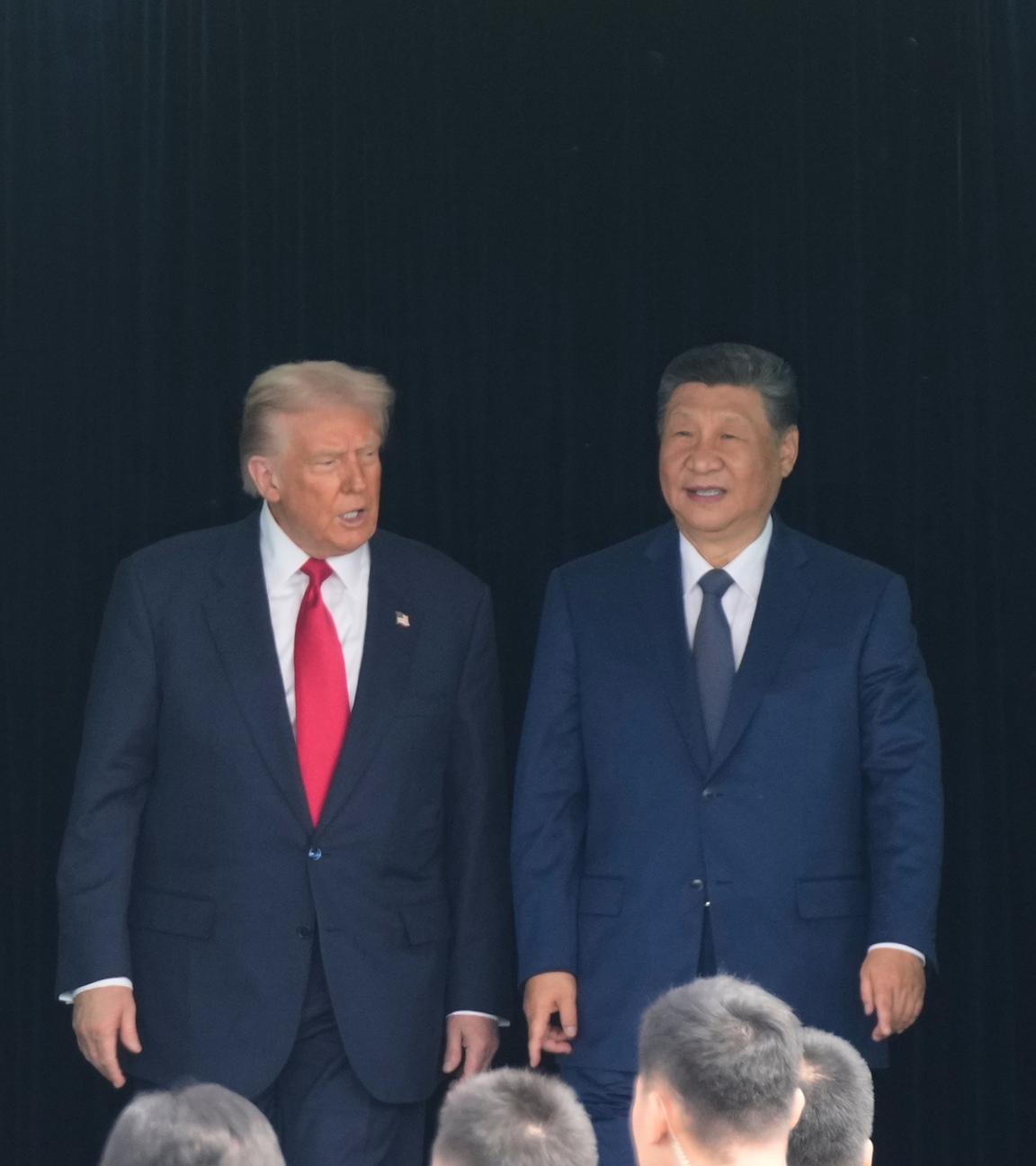 US-Präsident Donald Trump (l) und der chinesische Präsident Xi Jinping verlassen nach ihrem Treffen auf dem Gimhae International Airport Jinping ein Gebaude.