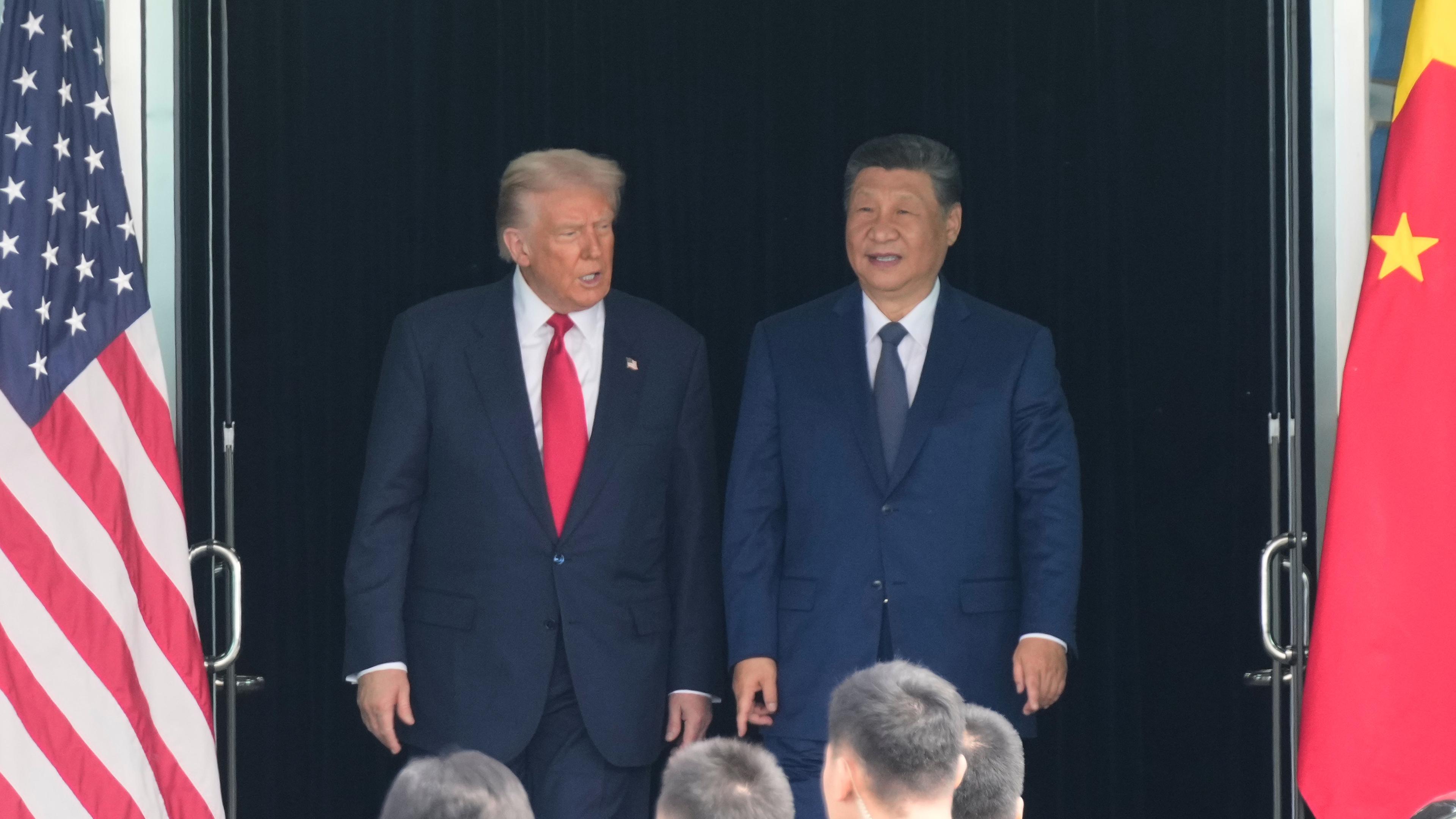 US-Präsident Donald Trump (l) und der chinesische Präsident Xi Jinping verlassen nach ihrem Treffen auf dem Gimhae International Airport Jinping ein Gebaude.
