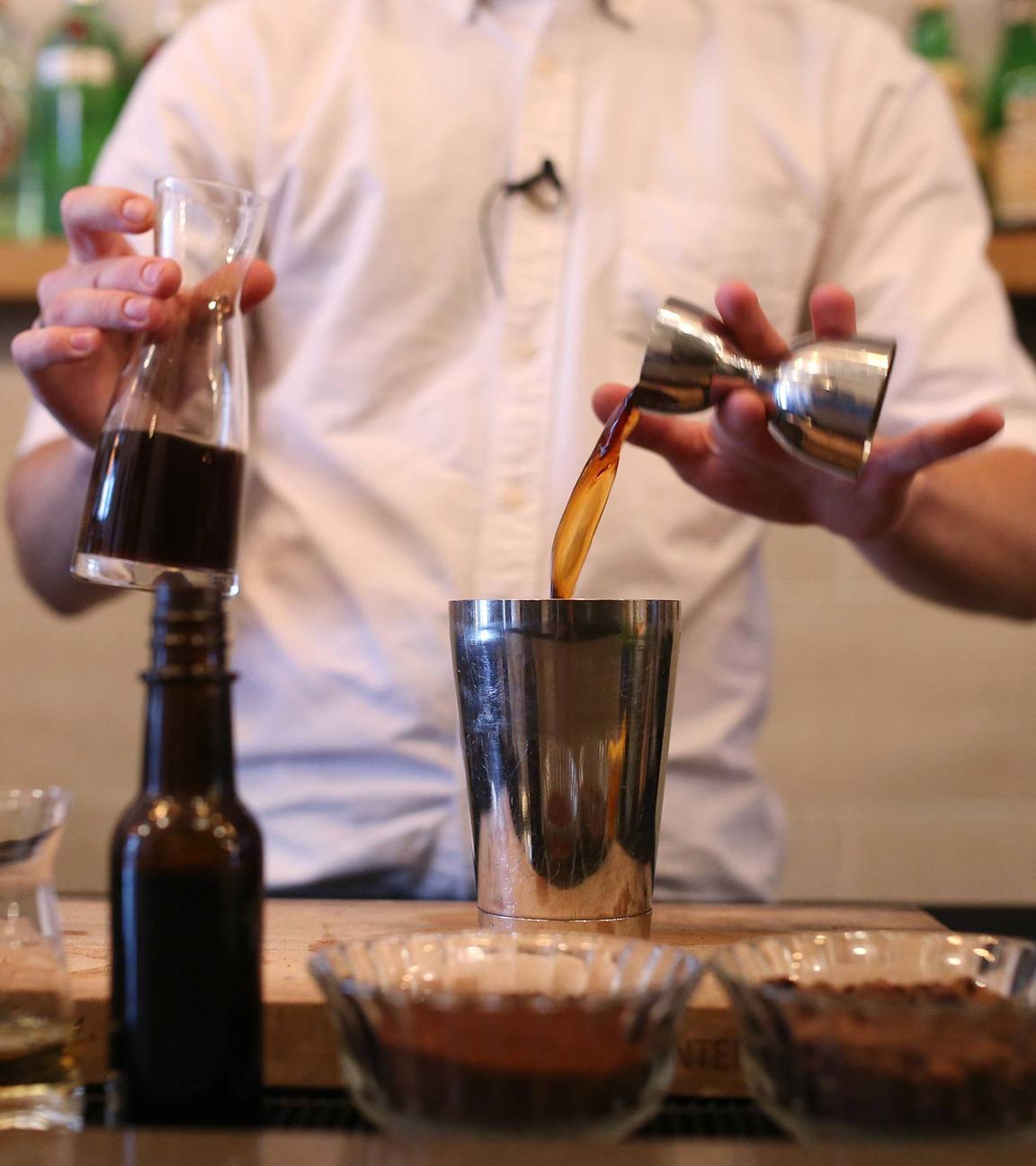 Barkeeper mixt einen Cocktail mit Kaffee.