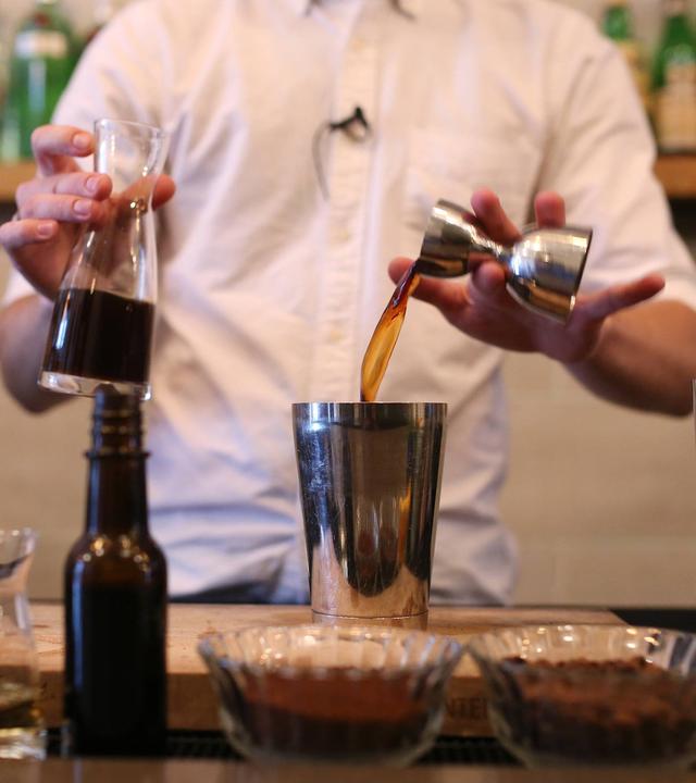 Barkeeper mixt einen Cocktail mit Kaffee.
