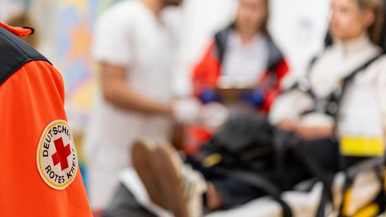 Das Abzeichen vom Deutschen Roten Kreuz ist auf der Jacke eines Rettungssanitäters im Rahmen der Katastrophenschutzübung "Löwenzahn" in der Triage der Notaufnahme des Universitätsklinikums Erlangen zu sehen.