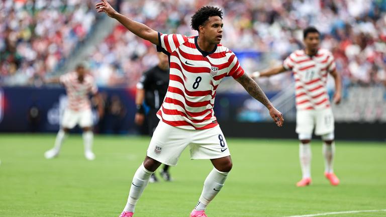 Der US-Amerikaner Weston McKennie streckt seinen rechten Arm in die Höhe, der Oberkörper ist leicht nach vorne gebeugt