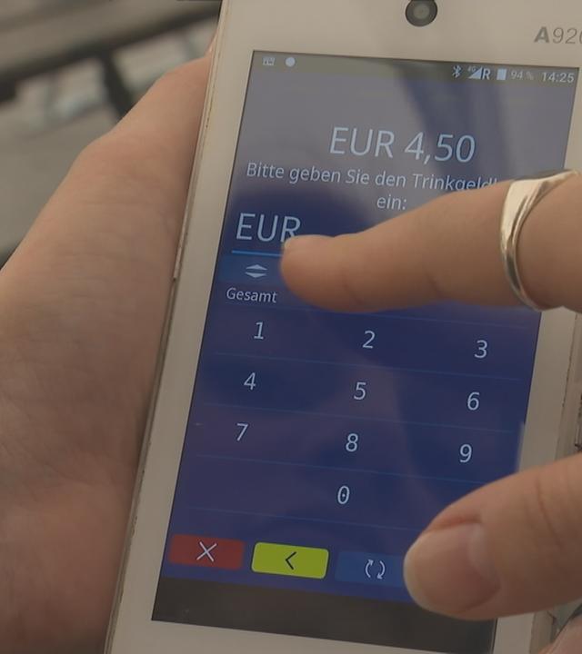 Person, die auf einem Touchscreen Trinkgeld eingeben möchte