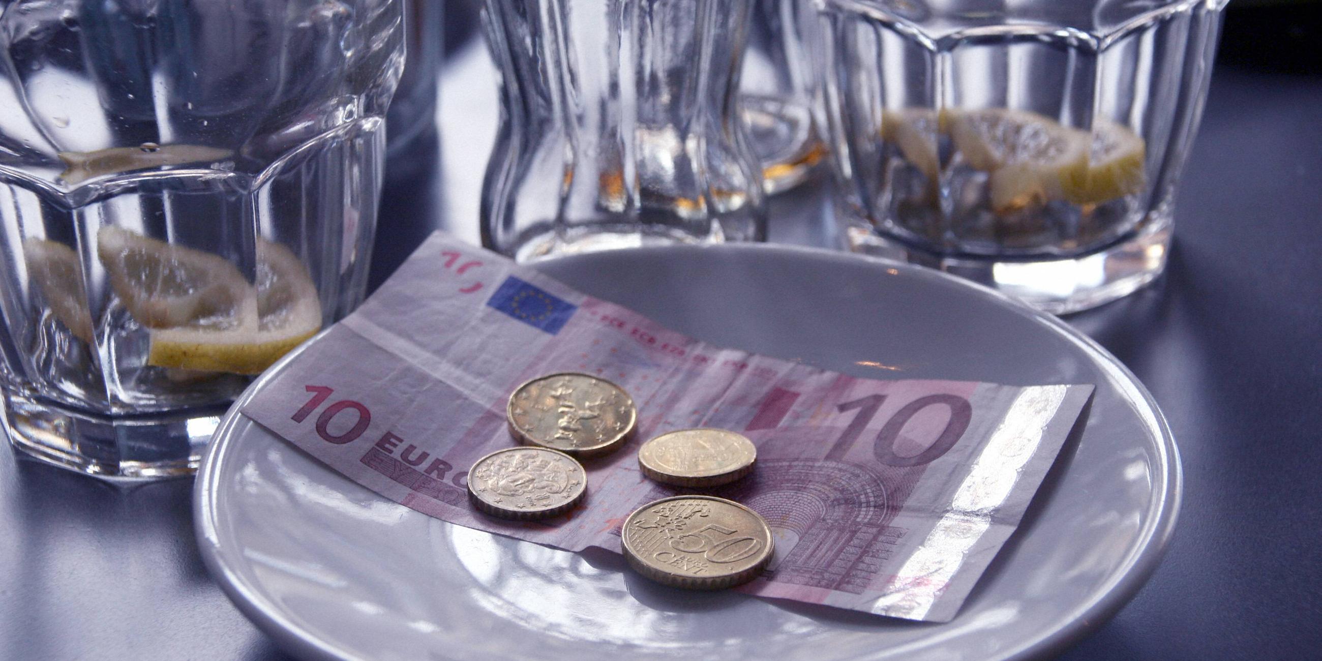 Trinkgeld neben leeren Gläsern auf einer Untertasse