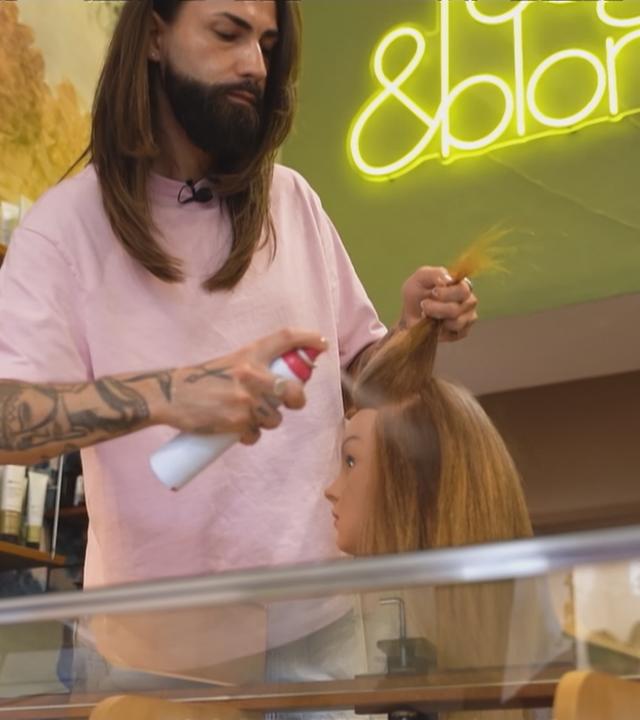 Ein Friseur benutzt ein Trockenshampoo.