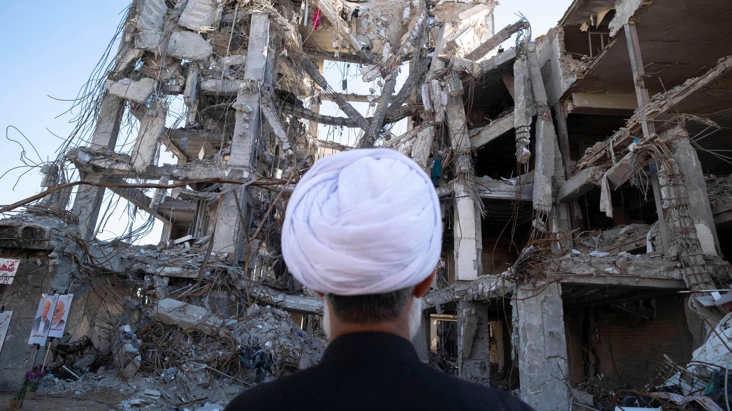 Ein iranischer Geistlicher steht am 09.04.2026 vor den Trümmern eines Gebäudes in einem Wohngebiet in Teheran, Iran.