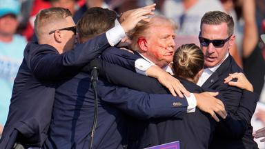 Der republikanische Präsidentschaftsbewerber und frühere US-Präsident Donald Trump wird nach einem Attentatsversuch von Agenten des US-Geheimdienstes Secret Service umringt.