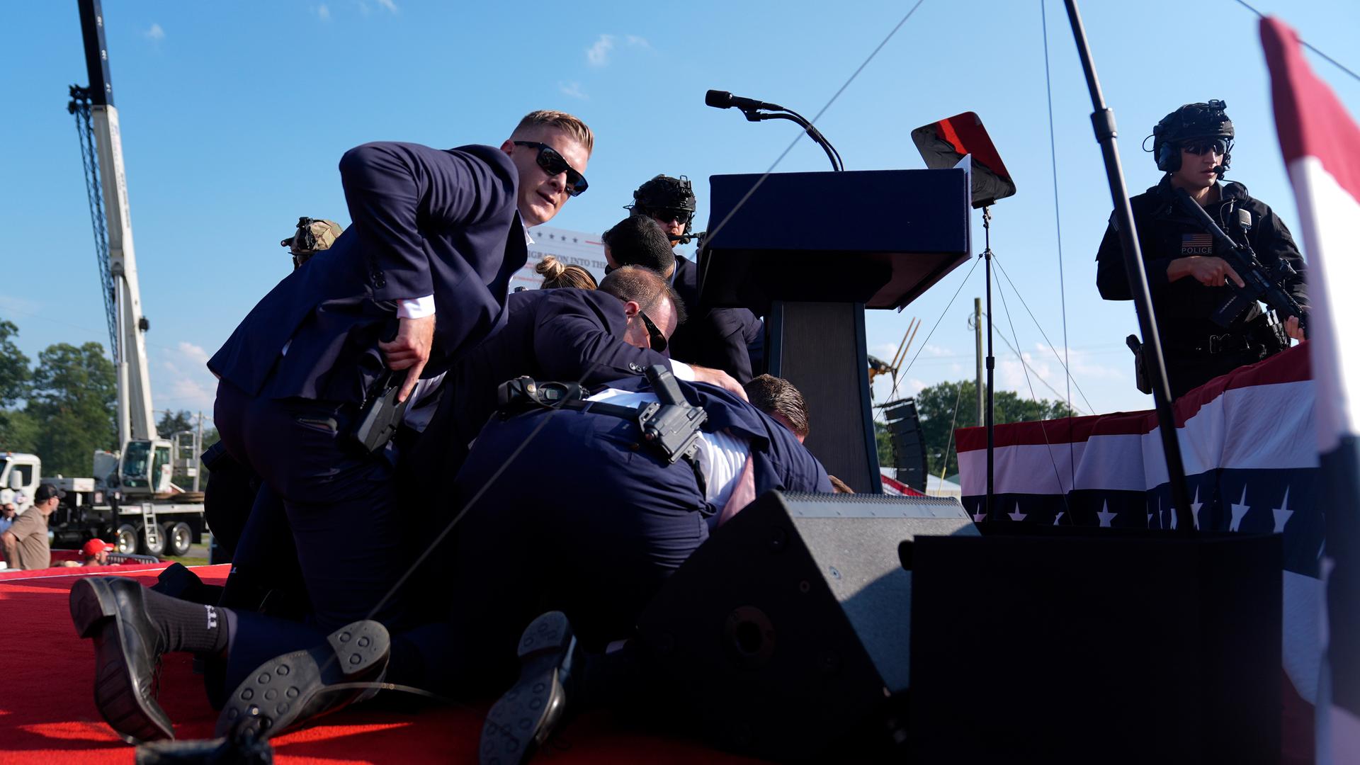 Donald Trump ist bei einer Wahlkampfveranstaltung nach einem versuchten Attentat von Personen des US-Geheimdienstes umgeben.