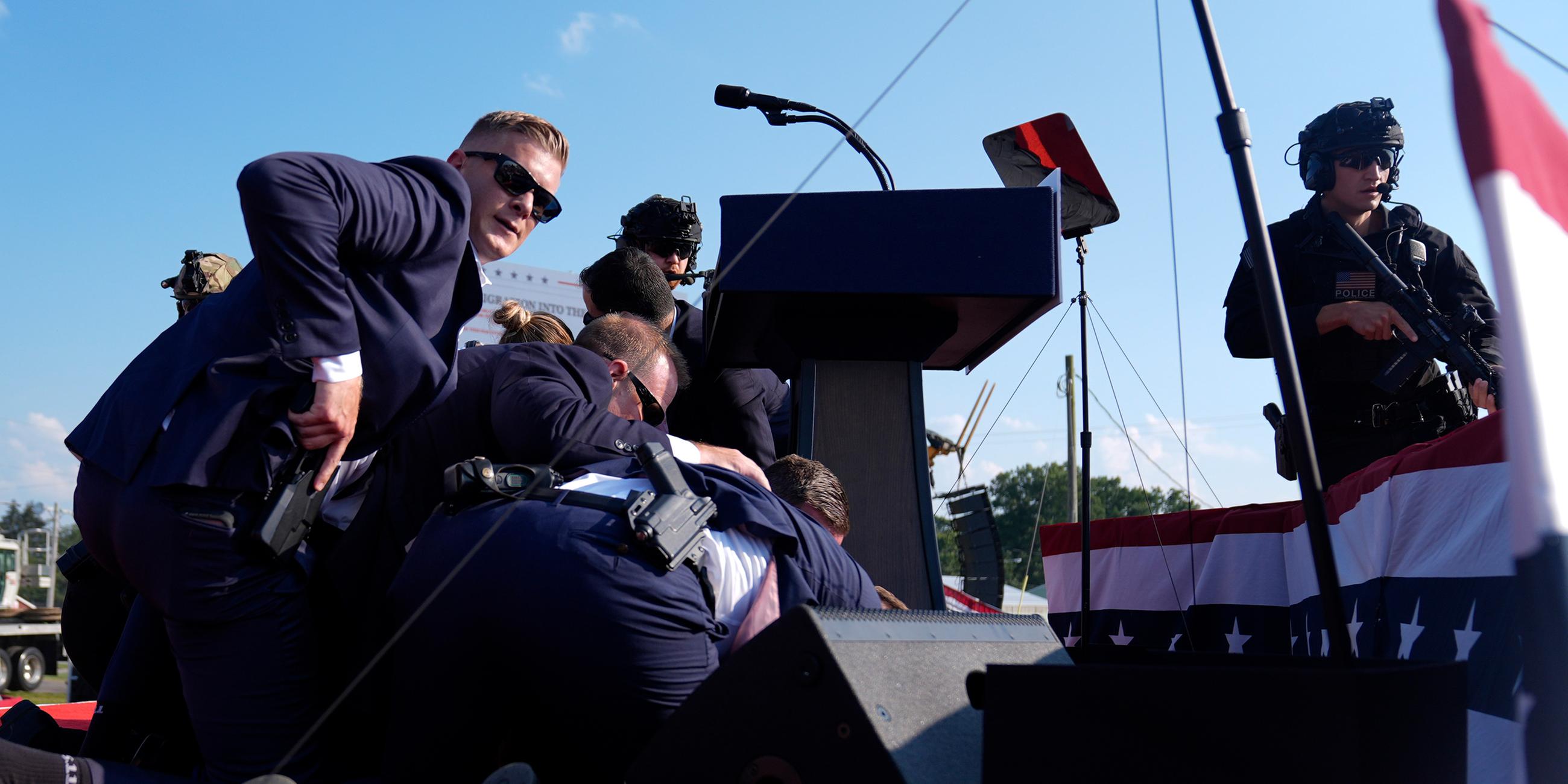 Donald Trump ist bei einer Wahlkampfveranstaltung nach einem versuchten Attentat von Personen des US-Geheimdienstes umgeben.