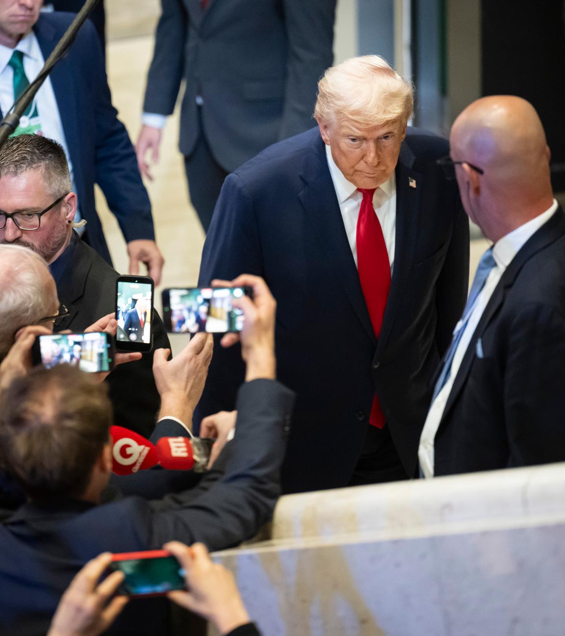 President Donald Trump leaves a plenary session in the Congress Hall, walking past journalists after his speech.