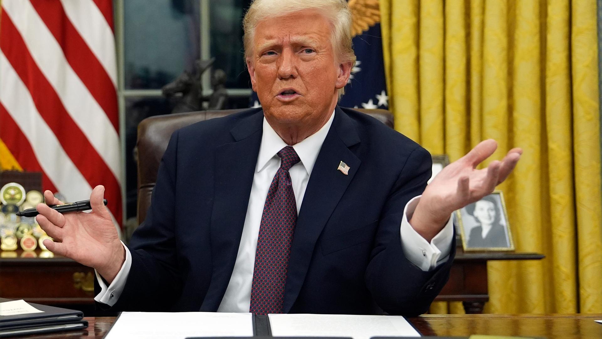 Präsident Donald Trump spricht mit Reportern, während er am  20. 1. 2025, im Oval Office des Weißen Hauses in Washington Executive Orders unterzeichnet. 