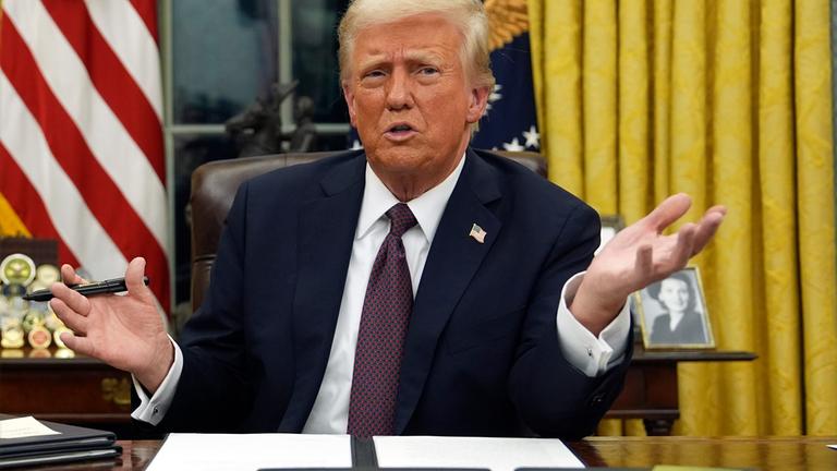 Präsident Donald Trump spricht mit Reportern, während er am  20. 1. 2025, im Oval Office des Weißen Hauses in Washington Executive Orders unterzeichnet. 