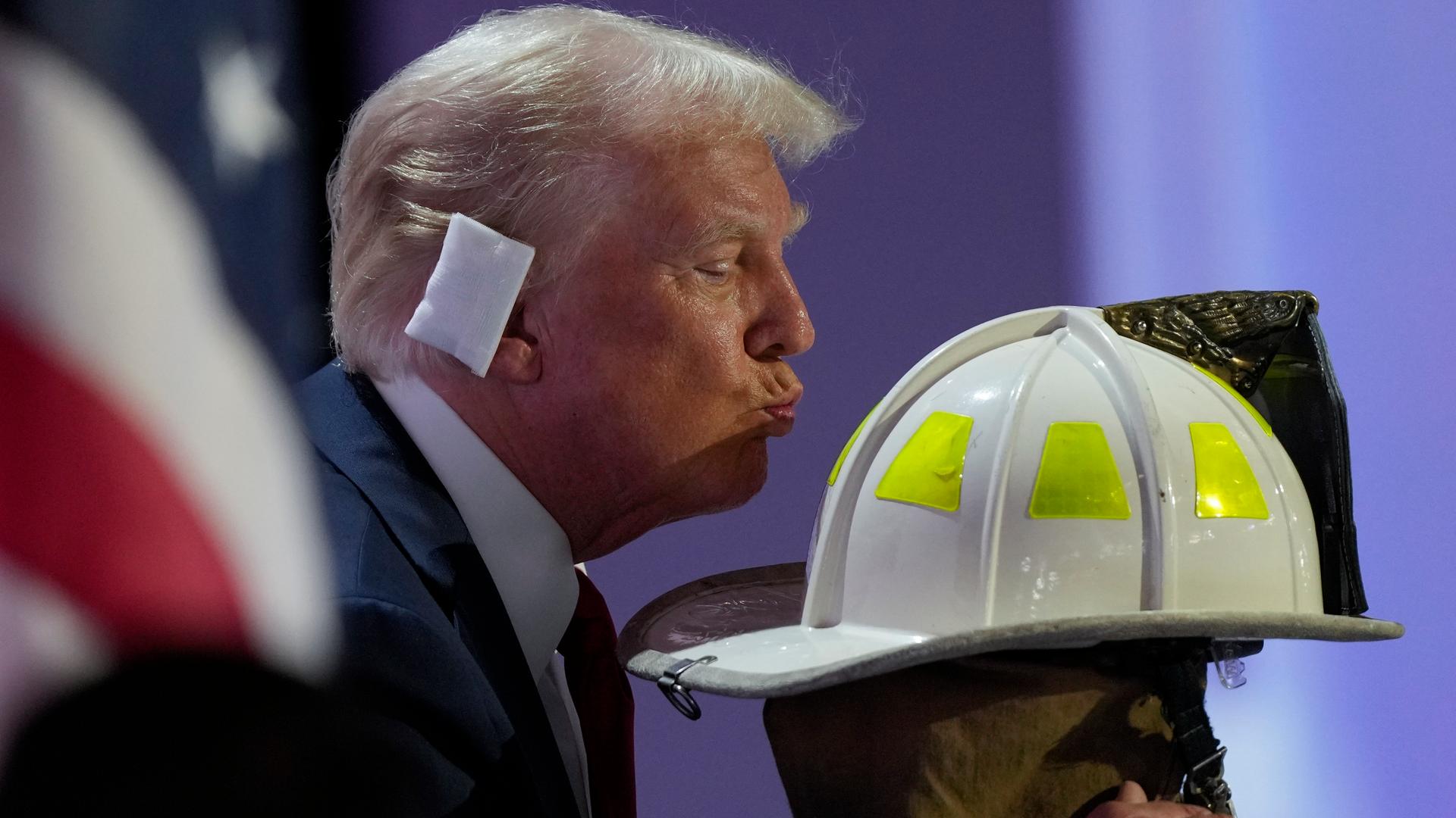 Donald Trump küsst den Feuerhelm von Corey Comperatore auf dem Parteitag der US-Republikaner in Milwaukee.