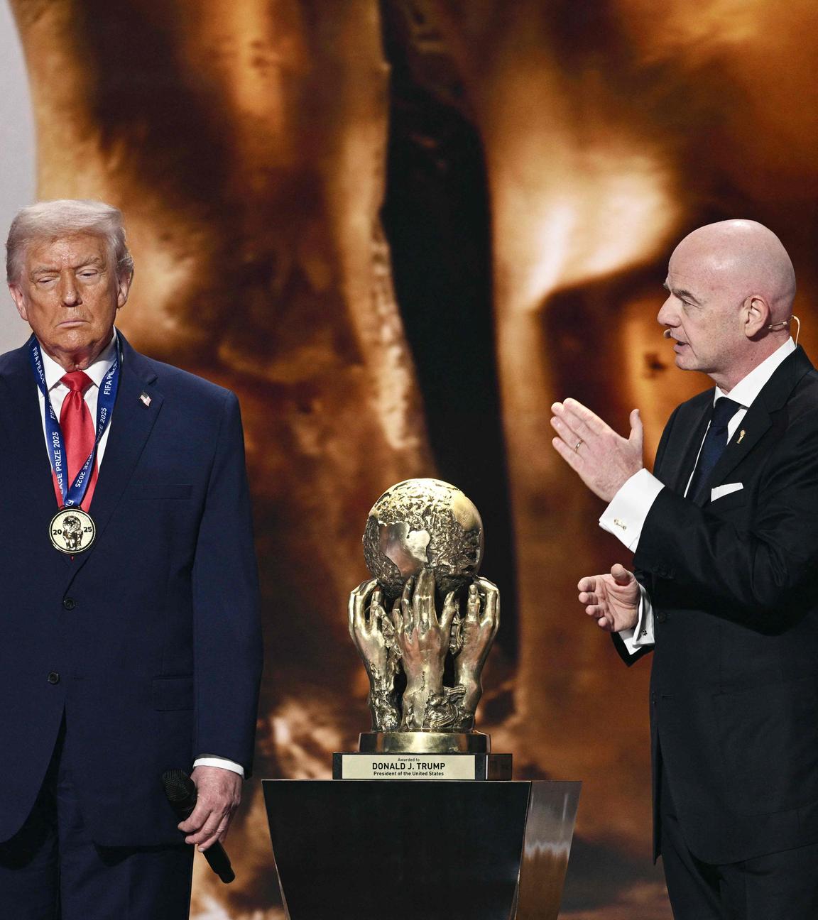 Fifa-Präsident Gianni Infantino beklatscht Donald Trump, der eine Medaille trägt und neben seinem erhaltenen Friedenspreis steht. 