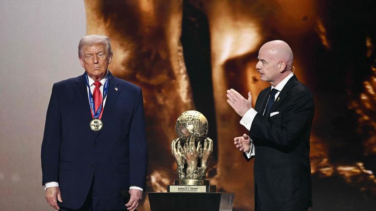 Fifa-Präsident Gianni Infantino beklatscht Donald Trump, der eine Medaille trägt und neben seinem erhaltenen Friedenspreis steht. 