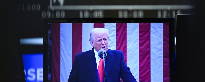 US-Präsident Trump ist auf einem Bildschirm auf dem Parkett der Frankfurter Wertpapierbörse vor der Anzeigetafel mit der Dax-Kurve zu sehen