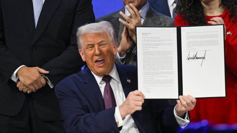 Trump hält die unterzeichnete Gründungsurkunde für seinen Friedensrat in die Höhe