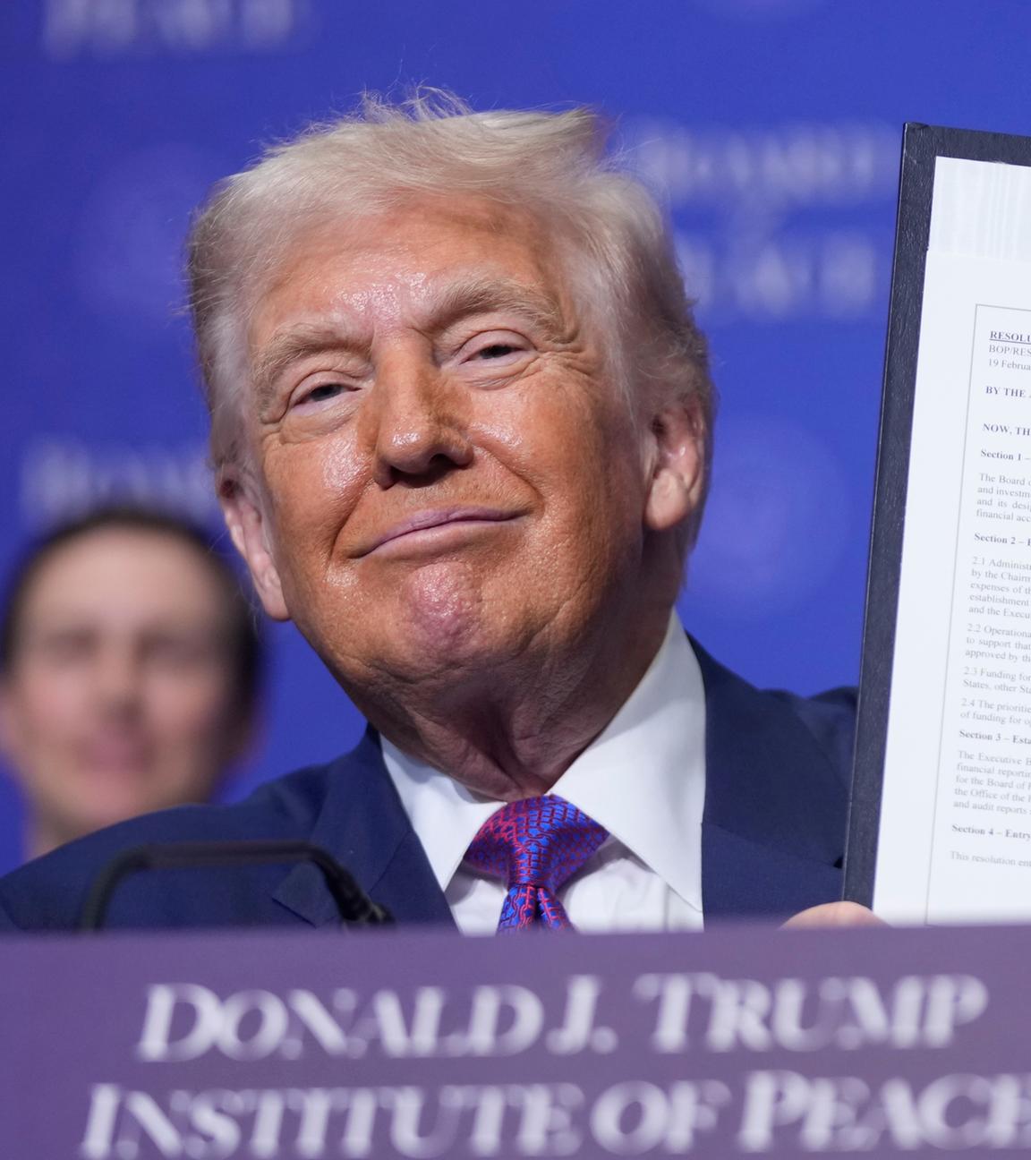 US-Präsident Donald Trump hält eine unterzeichnete Resolution während einer Sitzung des Friedensrats zur Beilegung globaler Konflikte im U.S. Institute of Peace hoch, am 19.02.2026