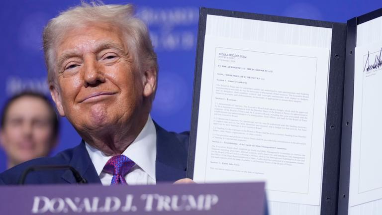US-Präsident Donald Trump hält eine unterzeichnete Resolution während einer Sitzung des Friedensrats zur Beilegung globaler Konflikte im U.S. Institute of Peace hoch, am 19.02.2026