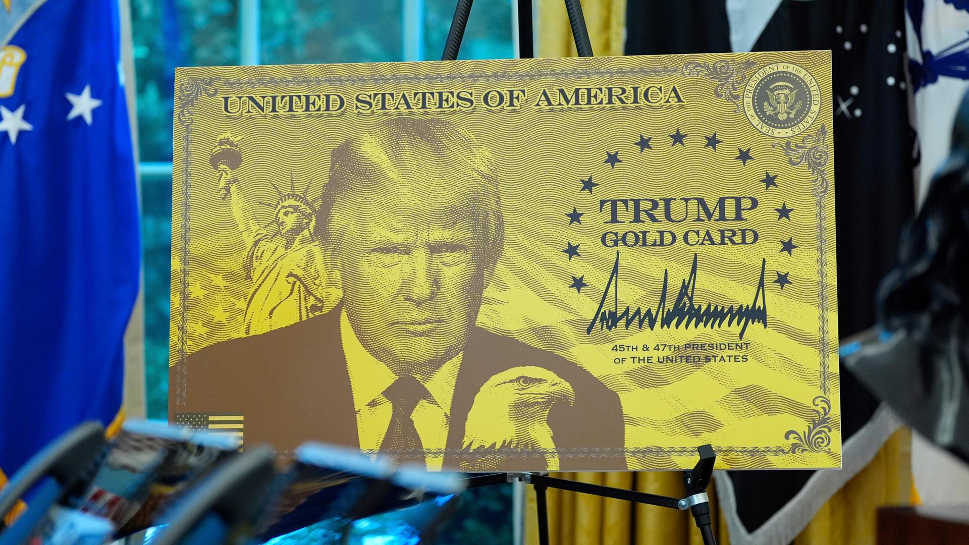 Archiv: Ein Poster mit der Trump Gold Card ist abgebildet, während US-Präsident Donald Trump im Oval Office des Weißen Hauses spricht.