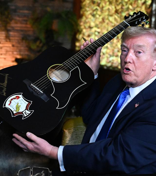 US-Präsident Donald Trump signiert eine Gitarre während seines Besuchs in Graceland, dem ehemaligen Wohnsitz des Sängers Elvis Presley, am 23. März 2026 in Memphis.