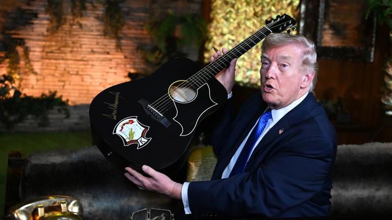 US-Präsident Donald Trump signiert eine Gitarre während seines Besuchs in Graceland, dem ehemaligen Wohnsitz des Sängers Elvis Presley, am 23. März 2026 in Memphis.