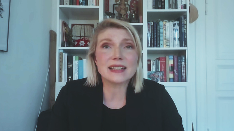 Politologin Cathryn Clüver Ashbrook vor einem weißen Bücherregal.