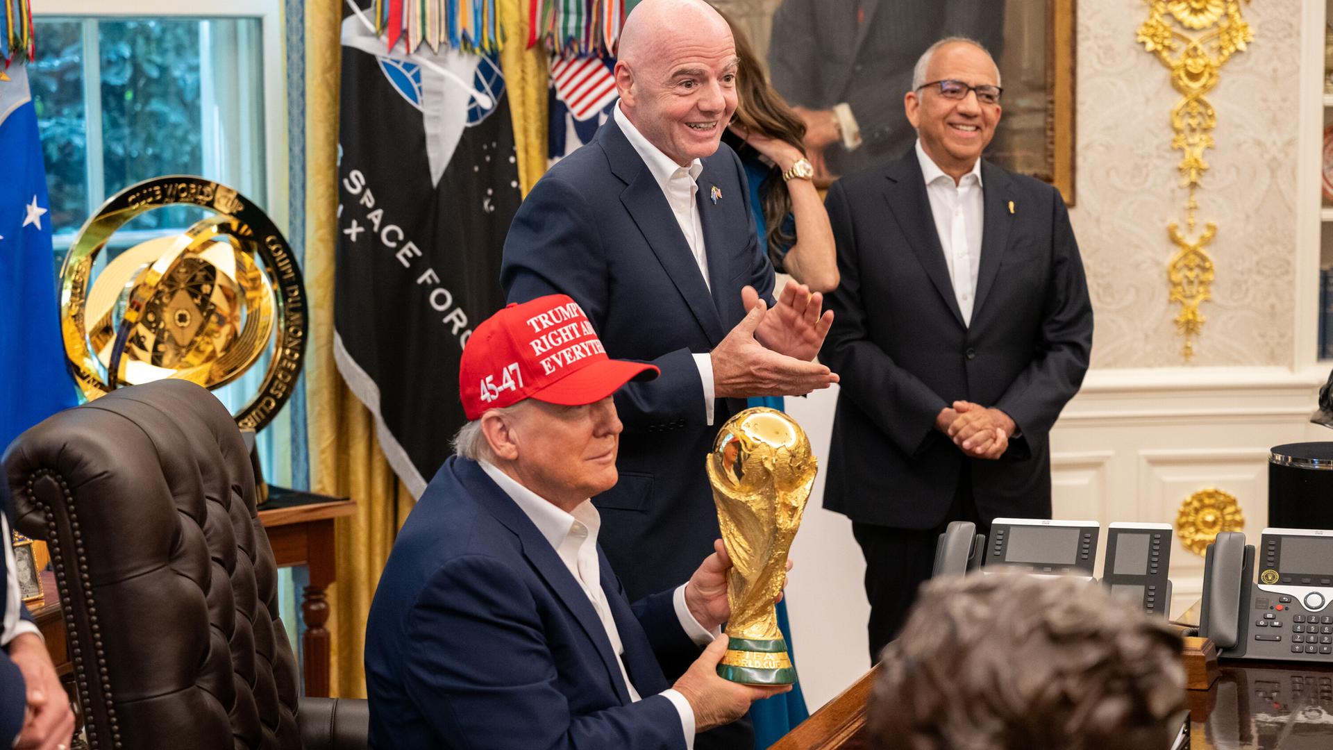 US-Präsident Donald Trump hält den WM-Pokal im Oval Office, FIFA-Chef Gianni Infantino spendet Applaus
