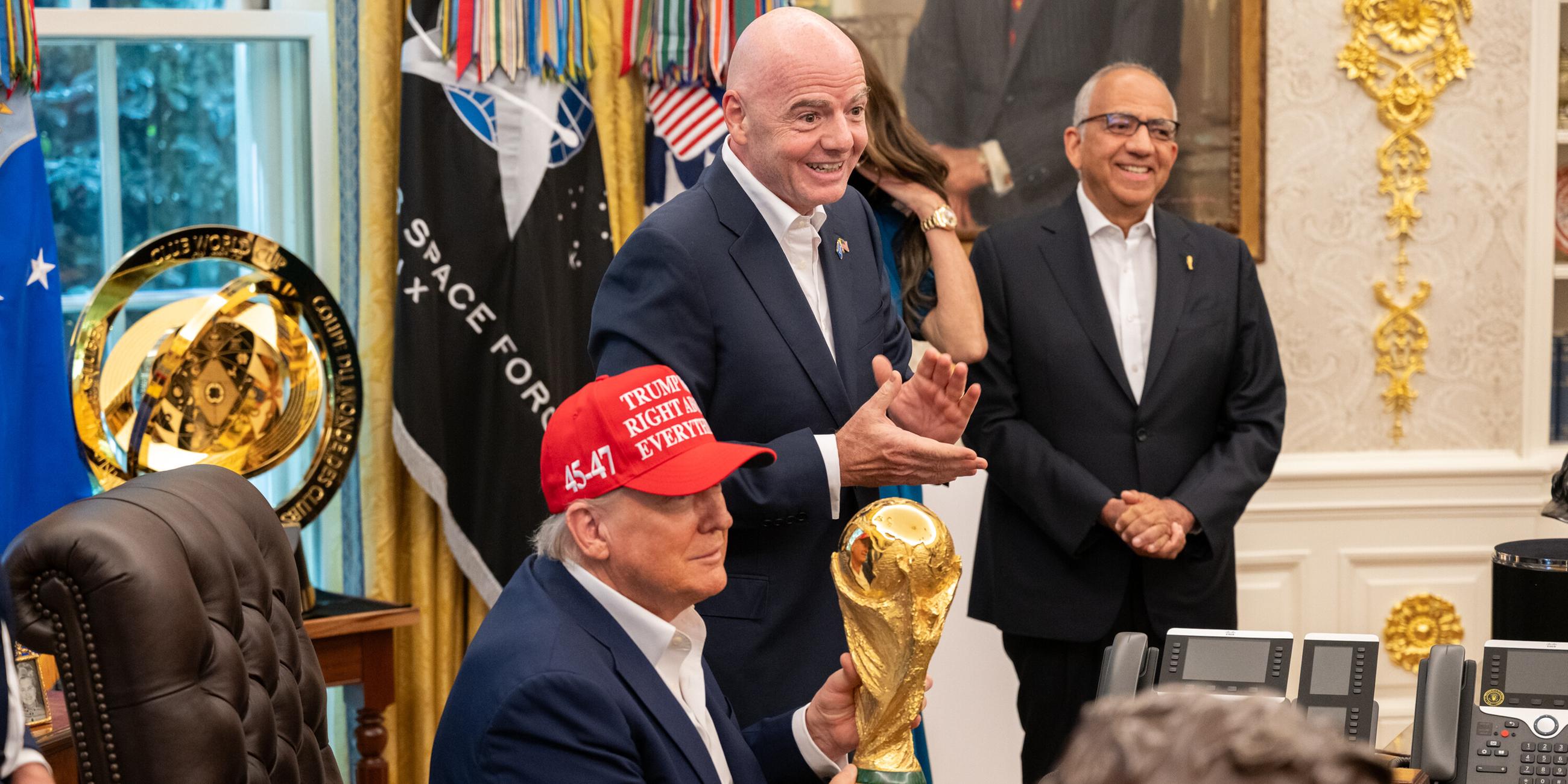 US-Präsident Donald Trump hält den WM-Pokal im Oval Office, FIFA-Chef Gianni Infantino spendet Applaus