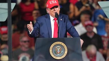Donald Trump trägt eine rote USA-Kappe und hält eine Rede bei einer Wahlkampfveranstaltung am Gastonia Municipal Airport.