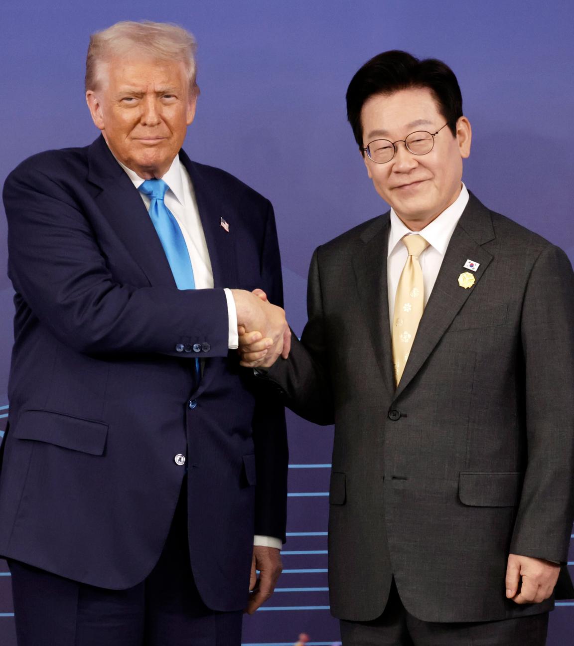 Der südkoreanische Präsident Lee Jae Myung (rechts) und US-Präsident Donald Trump (links) geben sich vor ihren Gesprächen die Hand