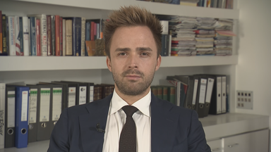 Politikwissenschaftler Julian Müller-Kaler in einem Anzug. Hinter ihm ein gefülltes Bücherregal.