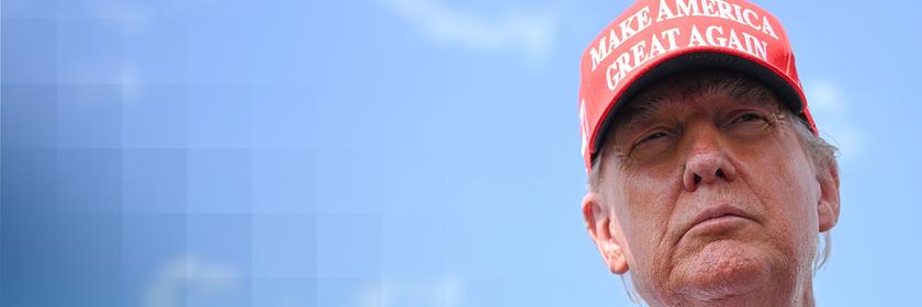 US-Präsident Donald Trump mit roter MAGA-Kappe auf dem Kopf. Der weiße Schriftzug sagt "Make America Great Again".