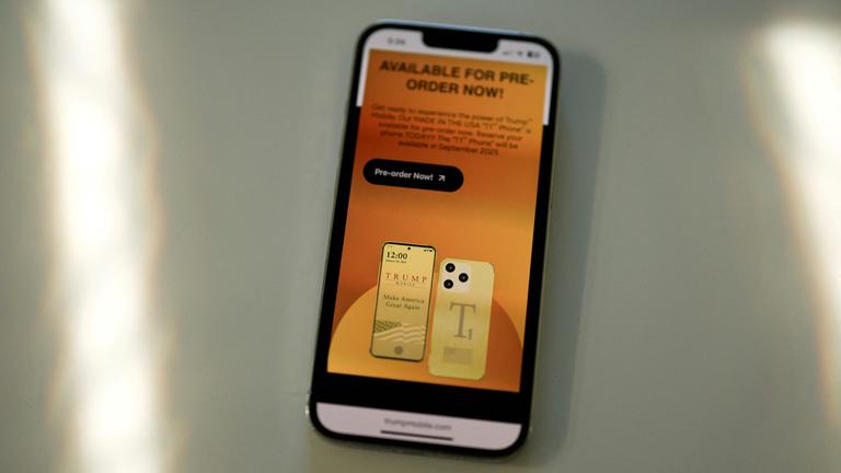 Ein iPhone am 16. Juni 2025 in Miami, Florida, die Website des Mobilfunkdienstes der Trump Organization und ein Smartphone mit der Marke Trump.