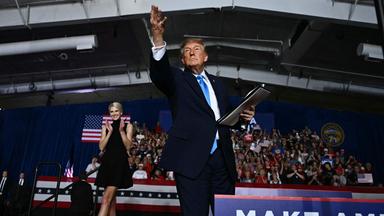 US President Donald Trump throws a pen into the crowd after he signed an executive order during a campaign rally at Pinnacle Bank Expo Center in Grand Island, Nebraska, on October 5, 2026. 