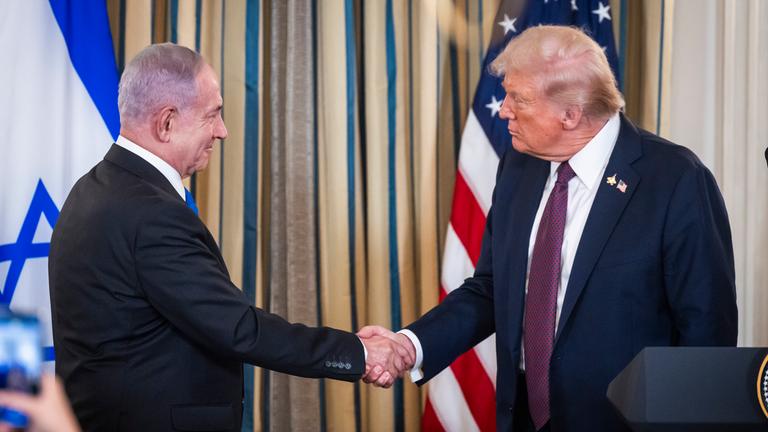 US President Donald Trump (R) shakes hands with Israeli Prime Minister Benjamin Netanyahu (L) after they spoke at a press conference in the State Dining Room of the White House in Washington, DC