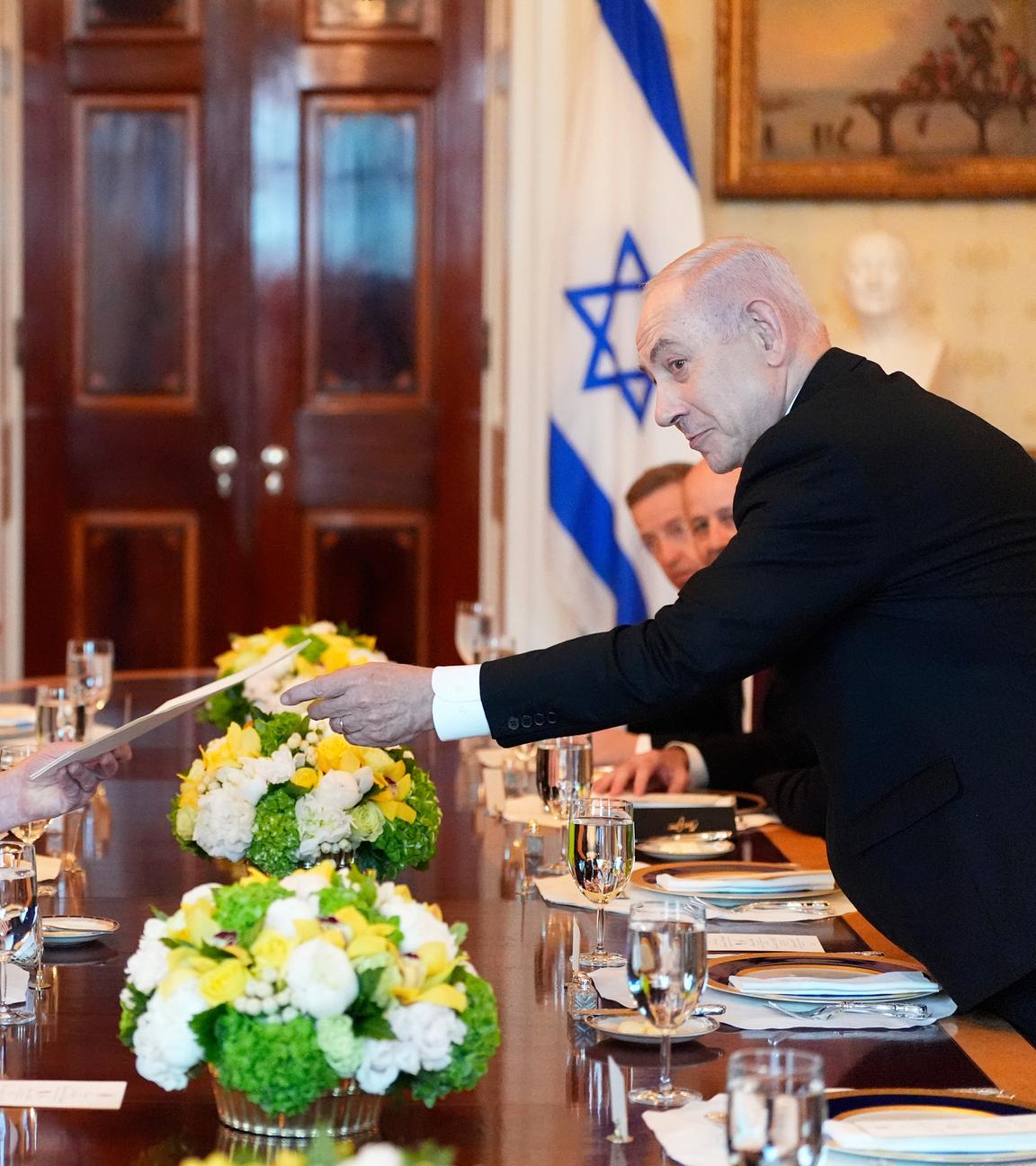 Benjamin Netanjahu (r), Ministerpräsident von Israel, überreicht US-Präsident Donald Trump eine Mappe während eines Treffens im Blue Room des Weißen Hauses in Washington.