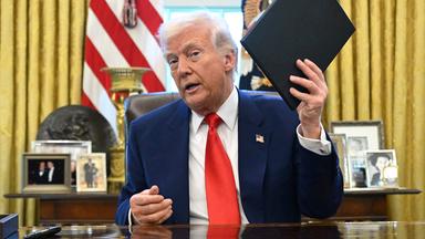 US-Präsident Trump mit Ordner in der Hand im Oval Office